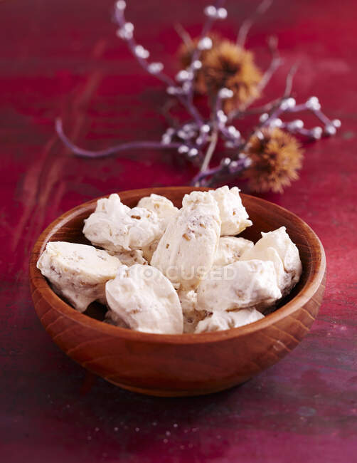 Meringues in wooden bowl with natural decorations on background — Stock Photo