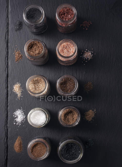 Différents types et couleurs de sel de cours dans des bocaux — Photo de stock