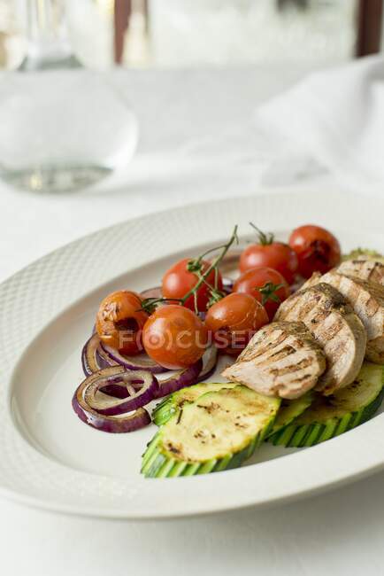 Grilled pork tenderloin with grilled tomatoes, zucchini and red onion — Stock Photo