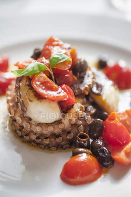 Fried octopus with cherry tomatoes and dark olives — Stock Photo