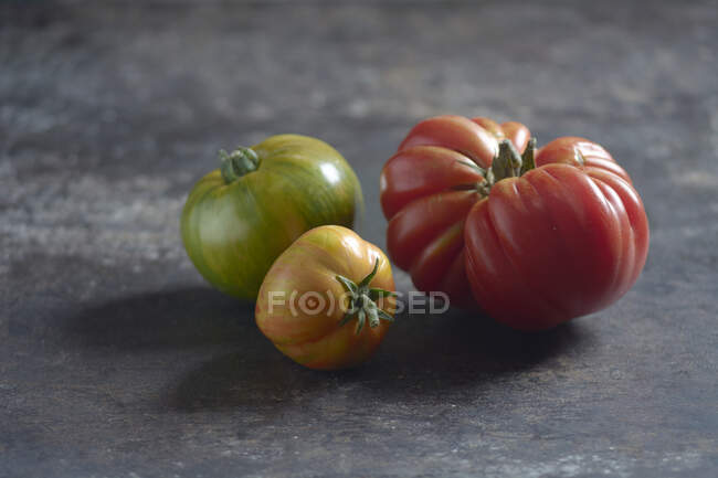 Zebra tomatoes and an ox heart tomato on a sheet metal — Foto stock