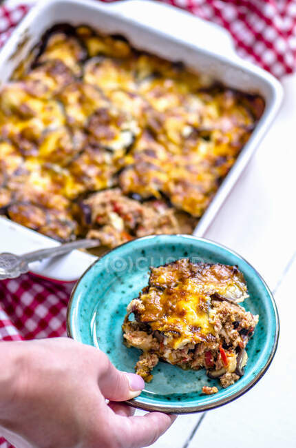 Moussaka on a plate and in a baking dish — Stock Photo