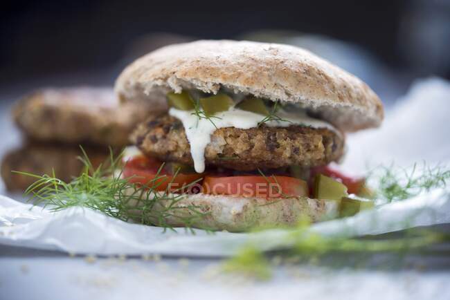 A burger with a millet fritter, tomato, and a dill and cucumber sauce — Stock Photo
