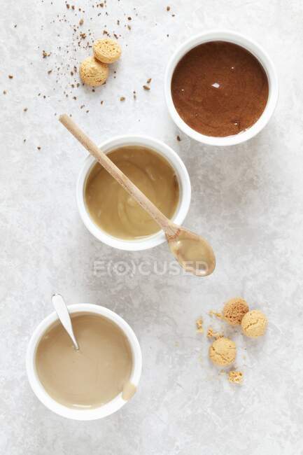 Шоколадний мус, карамель та кавовий соус у маленьких мисках — стокове фото