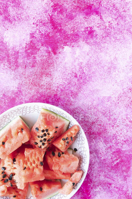 Fatias de melancia na placa de cerâmica no fundo rosa — Fotografia de Stock