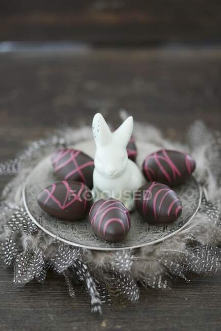 Шоколадные пасхальные яйца и фарфоровый кролик — стоковое фото