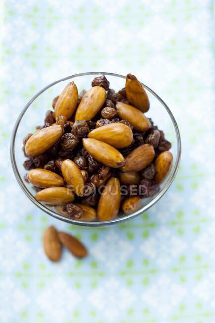 Almonds and raisins in a glass bowl — Stock Photo