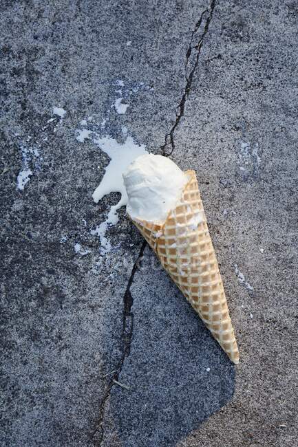 Un cono de helado sobre asfalto - foto de stock