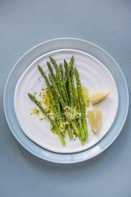 Green asparagus with garlic herb butter and lemon — Stock Photo