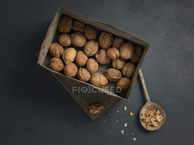 Вид зверху на свіжі волоські горіхи в дерев'яній коробці на чорному тлі — стокове фото