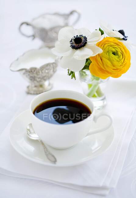 A cup of coffee, milk, sugar and a bunch of flowers — Foto stock