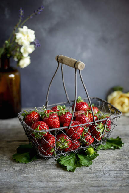 Fresas frescas en canasta de alambre vintage sobre fondo oscuro - foto de stock