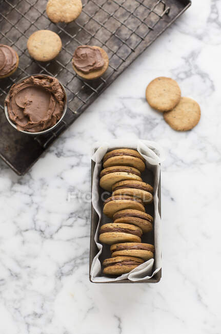 Sandwich cookies filled with chocolate cream in tin — Stock Photo