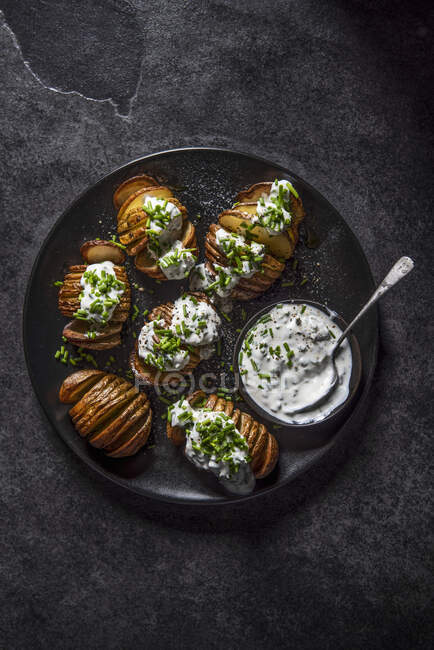 Chopped and roasted potatoes with sour cream and chives — Stock Photo