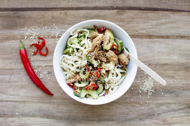 Rice noodles with soya and sesame chicken, cucumber and chili — Stock Photo