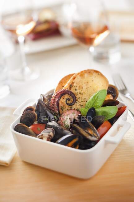 Mussel soup with squid and croutons — Stock Photo