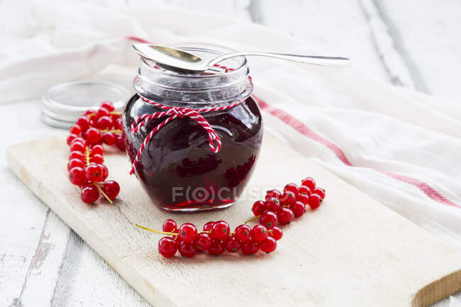 Jar of fresh cherry jam in glass jars on white wooden background — Stock Photo