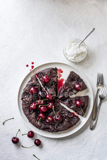 Chocolate, amaretto and cherry brownie with cream and fresh cherries — Stock Photo