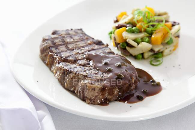 Bife de carne com molho de pimenta e timbale vegetal — Fotografia de Stock