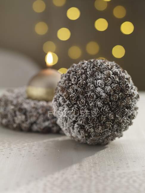 Una bagattella natalizia e una ghirlanda con una candela d'oro — Foto stock