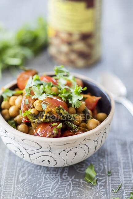 Bol de pois chiches aux tomates cerises et aux feuilles de curry — Photo de stock