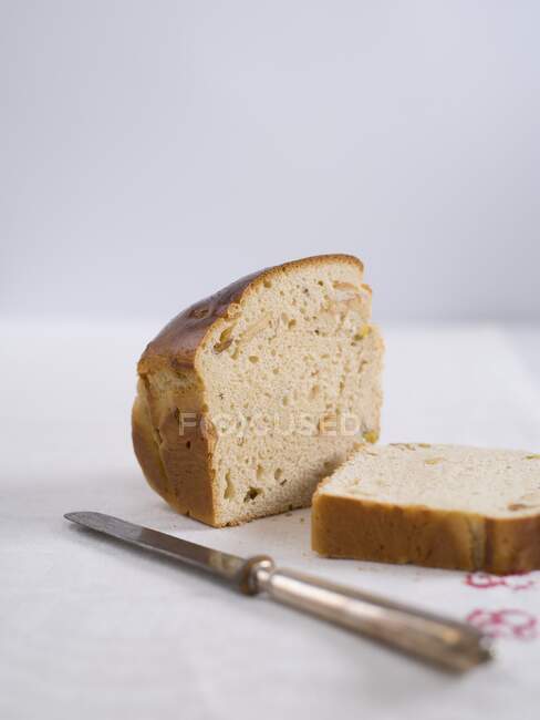 Бриош хлеб с фисташками и сушеные груши на столе с ножом — стоковое фото