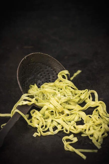 Herb tagliatelle on an old draining spoon — Stock Photo