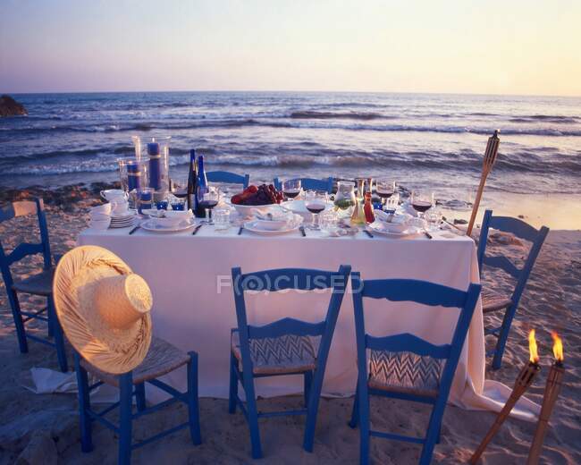 Покладений стіл на пляжі в сутінках — стокове фото