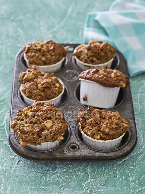 Apple and coconut muffins in a muffin tray — Stock Photo