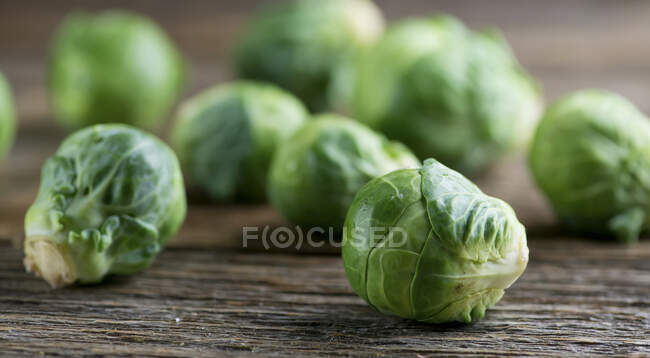Fresh green brussels sprouts on wooden table — Stock Photo