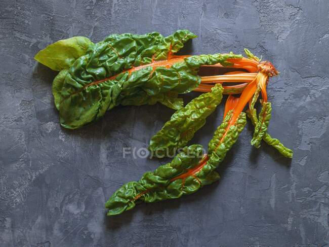 Green asparagus with spinach and mint leaves on a dark background. — Foto stock