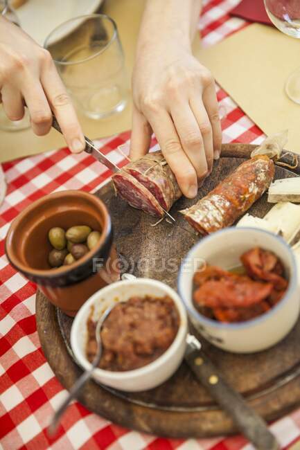 Salame su un piatto di legno su un tavolo in una taverna — Foto stock