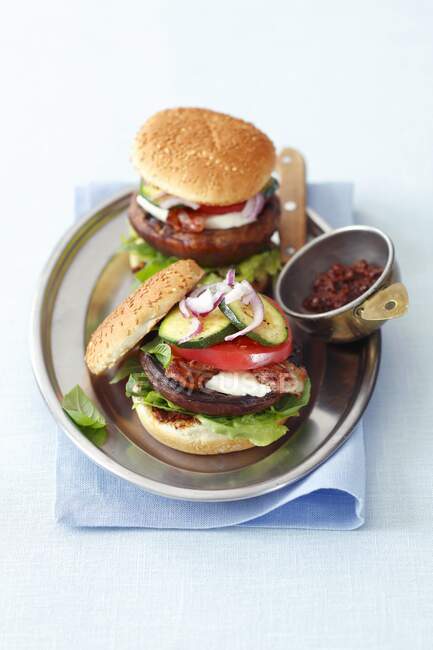 Hambúrgueres com cogumelos portobello grelhados, mussarela, bacon, tomate e courgette — Fotografia de Stock