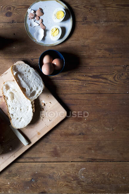 Uova sode su un piatto con pane su un tavolo di legno — Foto stock