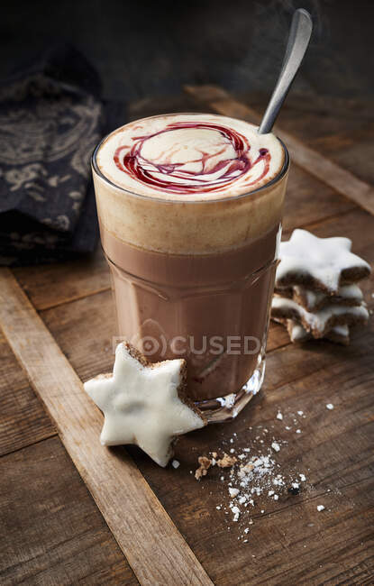 Hot chocolate with cherry sauce and cinnamon stars — Stock Photo