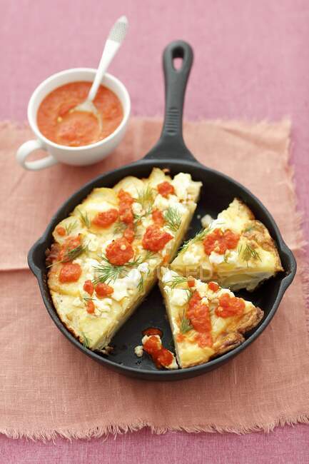 Potatoes tortilla with feta cheese and roasted pepper sauce in pan — Stock Photo