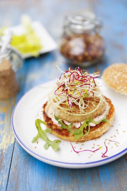 A fish burger with pink sauce and bean sprouts — Stock Photo