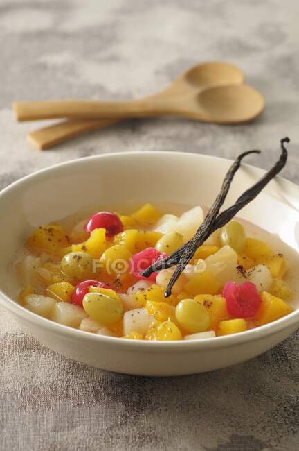Close-up shot of delicious Fruit salad with vanilla pods — Stock Photo