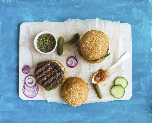Frischer Rindfleisch-Burger mit Käse, Gemüse und würziger Tomatensauce — Stockfoto