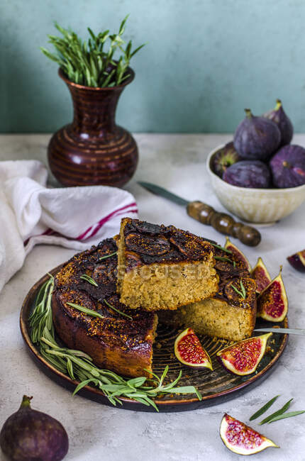 Torta rovesciata in un taglio con fichi, rosmarino e miele su fondo di cemento — Foto stock