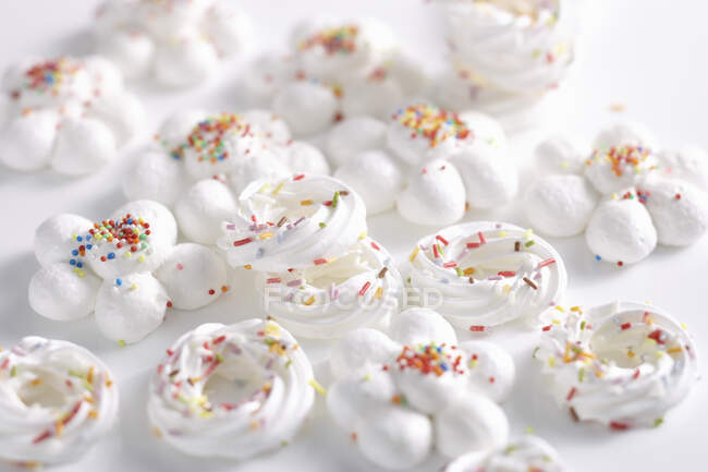 Delicate white meringues with colorful sprinkles — Stock Photo