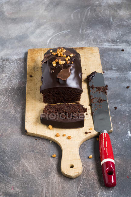 Chocolate cake on a wooden plank on a grey backdrop — Stock Photo