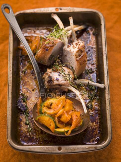 Pork chops with thyme and pumpkin in a roasting tin — Stock Photo