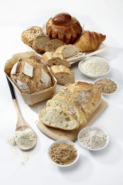 Vários pães orgânicos, brioche, croissant e diferentes tipos de farinha — Fotografia de Stock