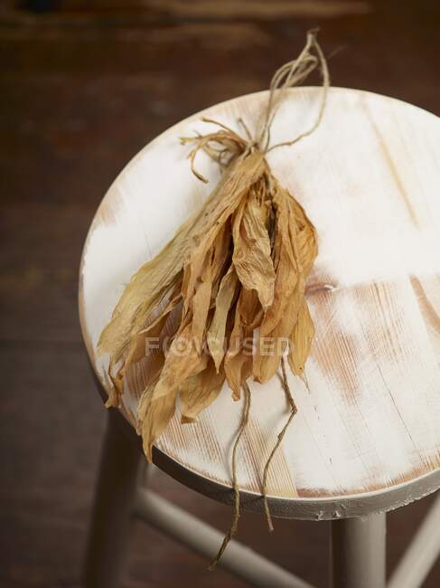 Dried wild garlic leaves on a wooden chair — Stock Photo
