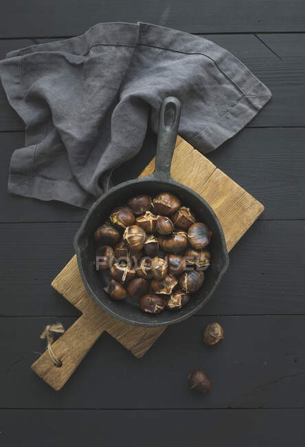 Roasted chestnuts in iron skillet pan — Stock Photo