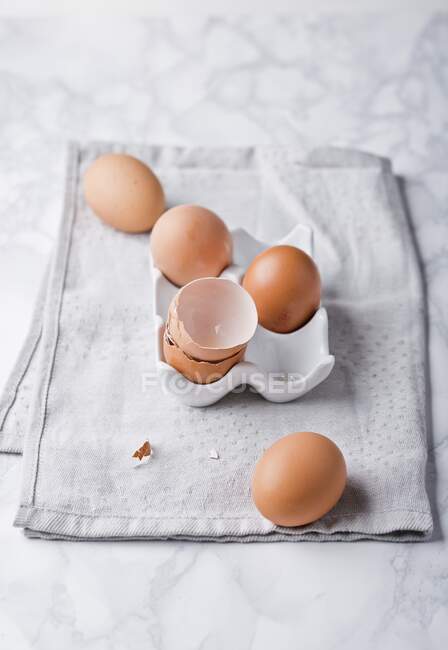 Uova e gusci d'uovo su supporto e tovagliolo di stoffa — Foto stock
