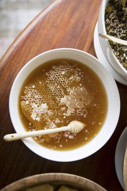 Honey with honeycomb and a honey dipper — Stock Photo