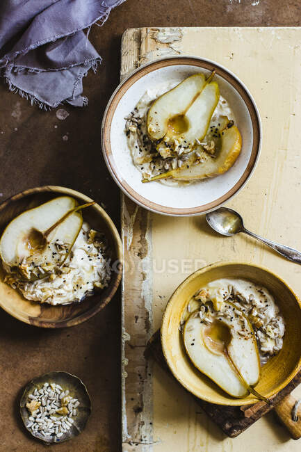 Peras asadas con mascarpone, miel, nueces, semillas de sésamo y girasoles - foto de stock