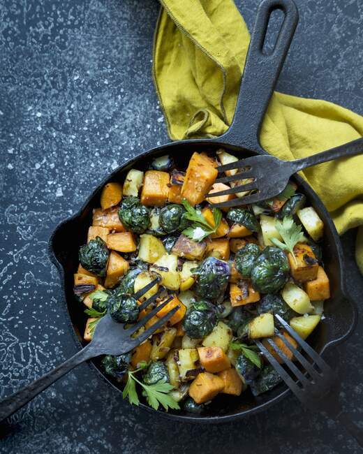 Fried sweet potatoes, potatoes and brussels sprouts with parsley — Stock Photo